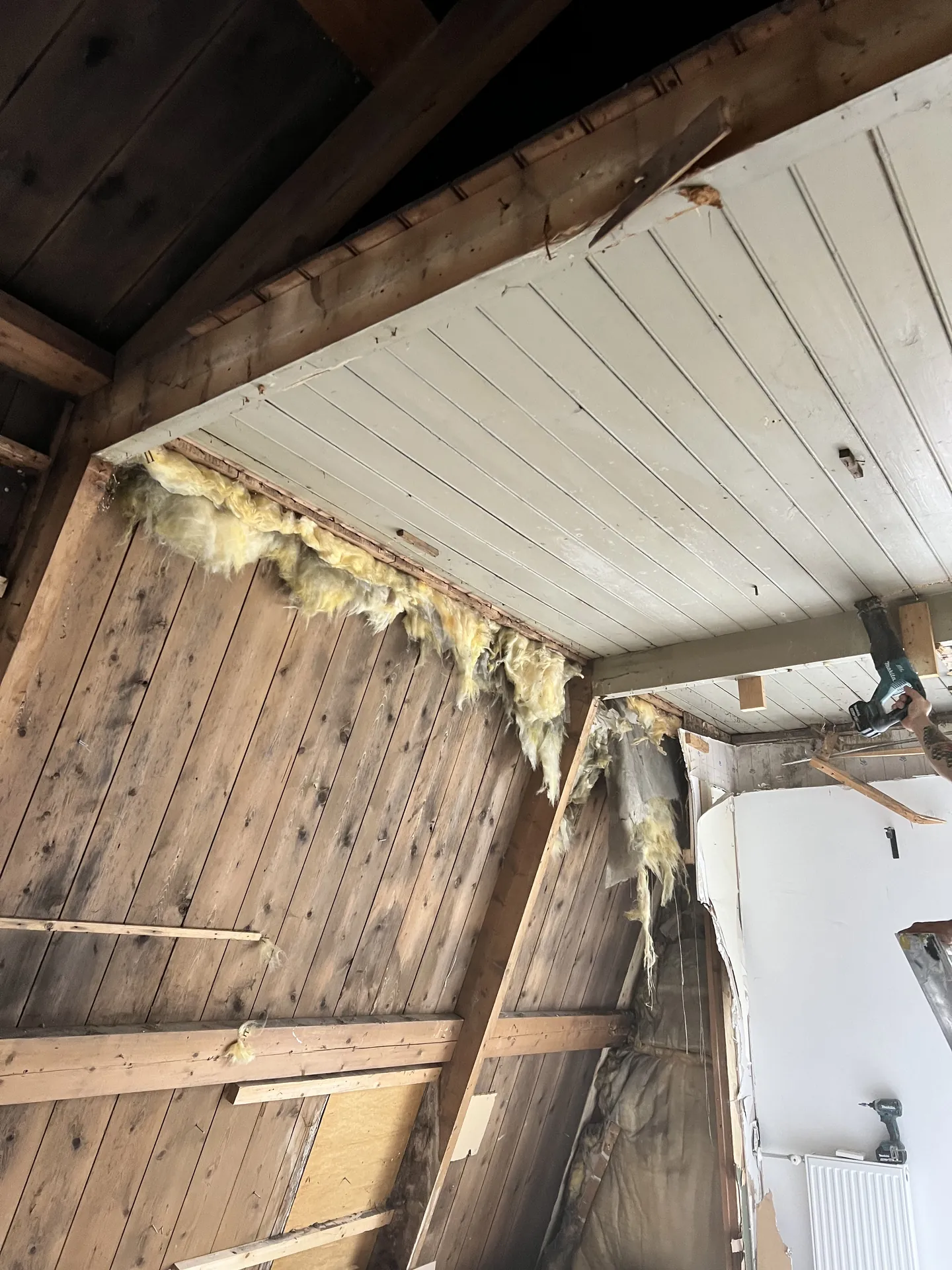 Gestript interieur met oude houten dakbeschieting en isolatieresten