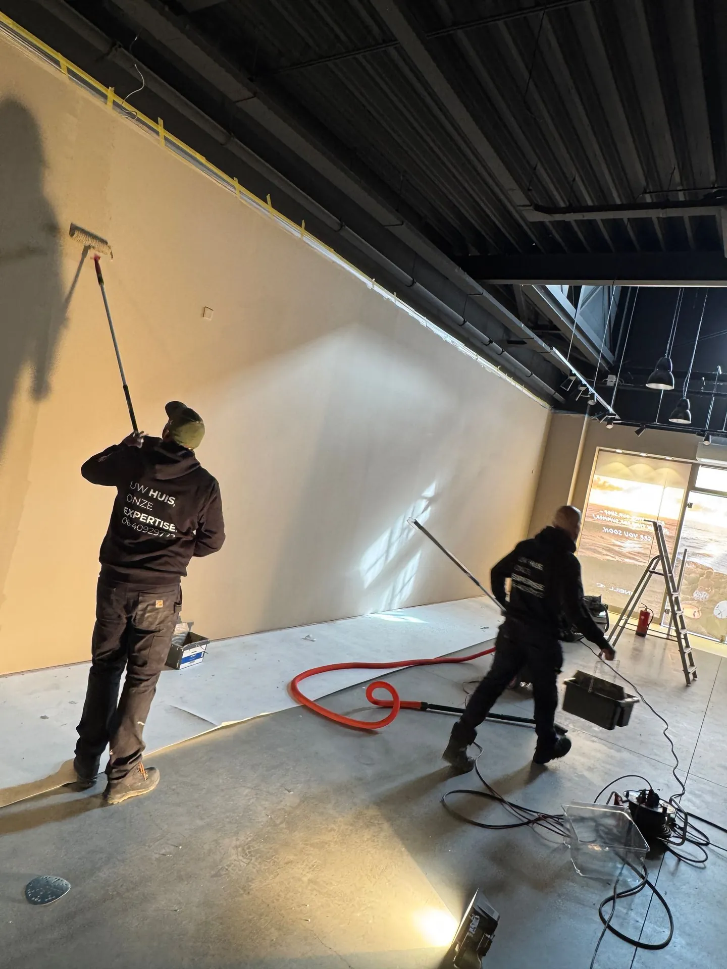 Schilders aan het werk aan de winkelwanden
