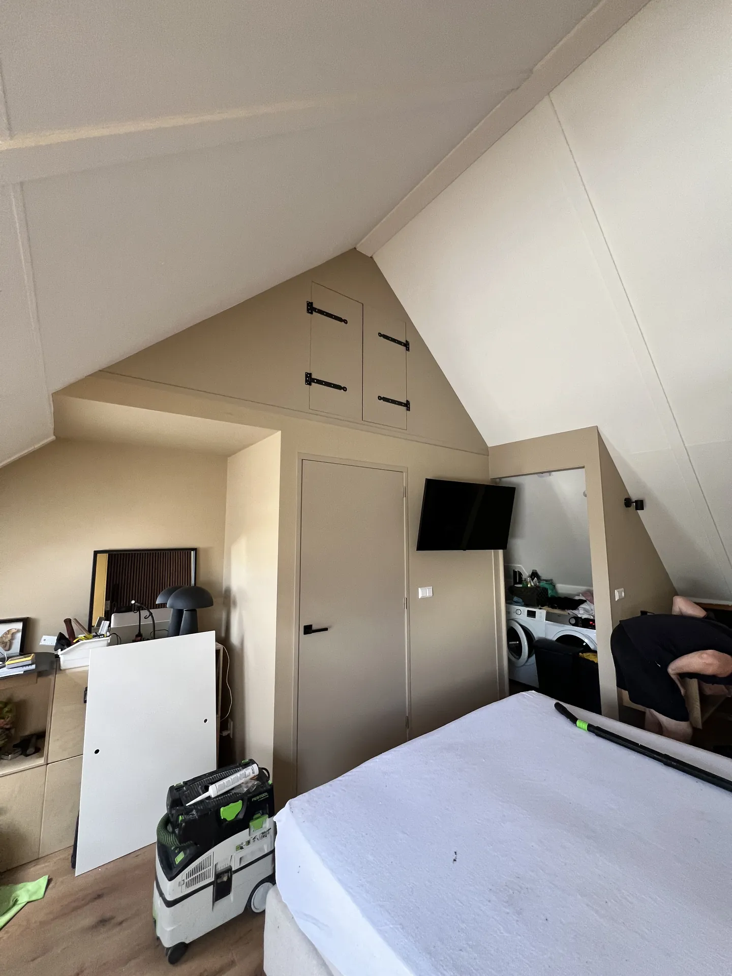 Zolder met maatwerkkasten, deuren en tv aan de wand