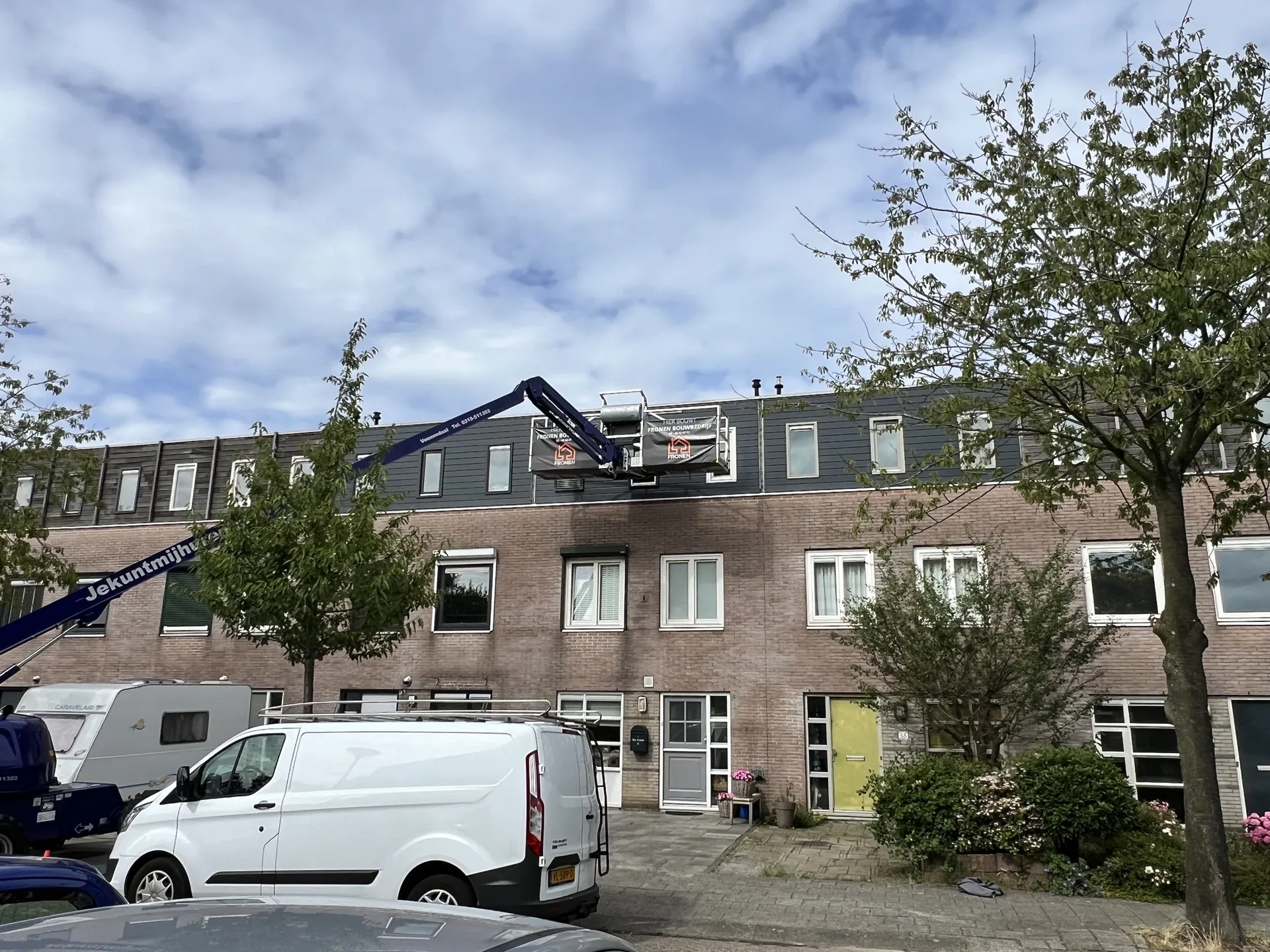 Gevelrenovatie van een rij woningen in Velserbroek met hoogwerker