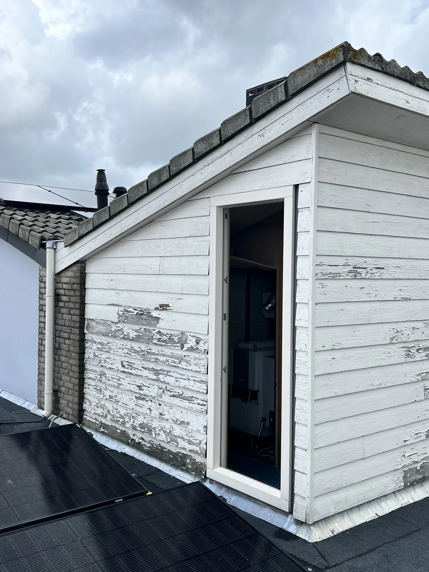 Oude, verweerde gevelbekleding vóór de renovatie